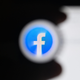 An image of the Facebook logo shrouded in black on a laptop screen.